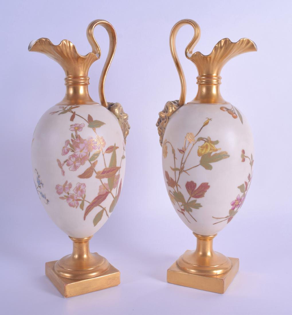 Royal Worcester fine pair of wine ewers with an ivory: Royal Worcester fine pair of wine ewers with an ivory ground painted with flowering plants having a gilt satyr mask handle. 28cm High