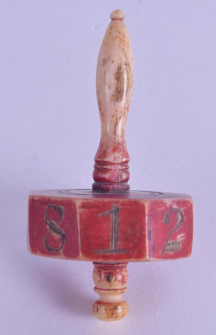 AN UNUSUAL GEORGE III CARVED BONE SPINNING DICE with: AN UNUSUAL GEORGE III CARVED BONE SPINNING DICE with painted central banding. 6.5 cm long.