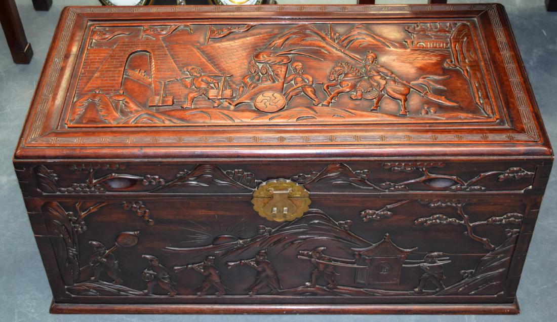 AN EARLY 20TH CENTURY CHINESE CARVED HARDWOOD: AN EARLY 20TH CENTURY CHINESE CARVED HARDWOOD RECTANGULAR CASKET unusually well carved with figures within landscapes in various pursuits.100 cm x 50 cm.
