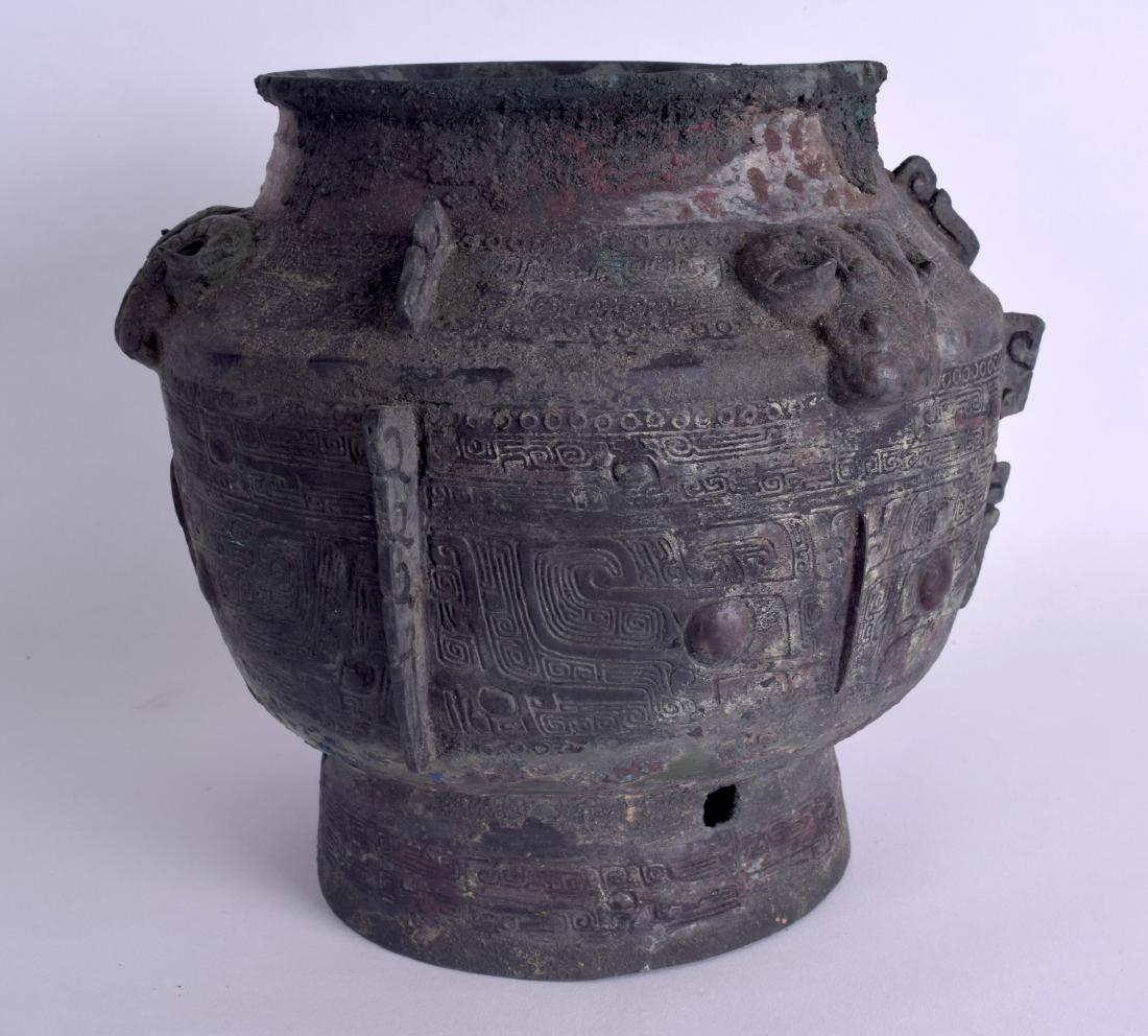 A CHINESE SHANG DYNASTY STYLE BRONZE BU WINE VESSEL: A CHINESE SHANG DYNASTY STYLE BRONZE BU WINE VESSEL with taotie designs and rams on the shoulders. 23 cm x 25 cm.