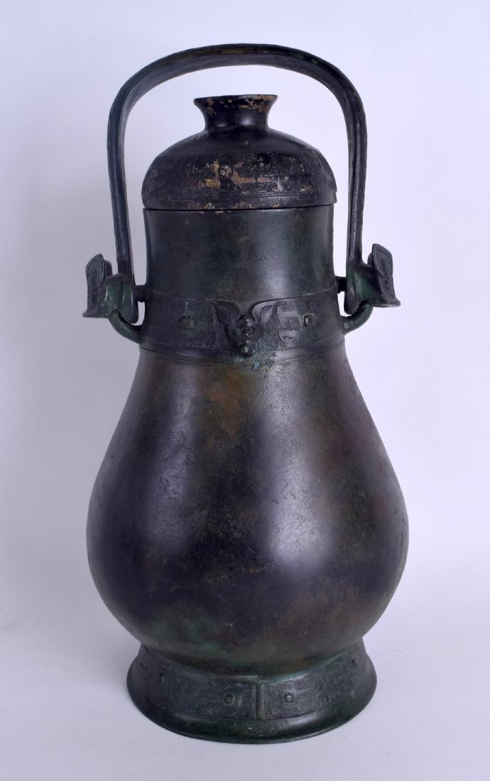A CHINESE SHANG DYNASTY STYLE BRONZE YOU WINE VESSEL of: A CHINESE SHANG DYNASTY STYLE BRONZE YOU WINE VESSEL of ovoid form with detachable cover, inscribed Yuan Zu Xin. 36 cm x 18 cm.