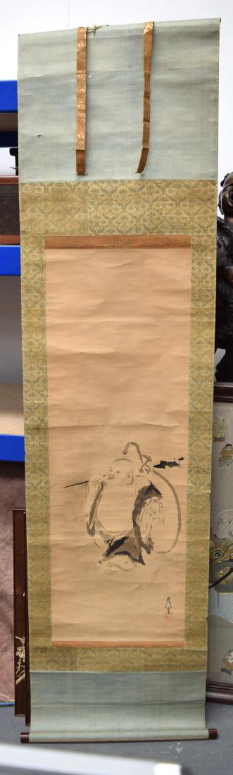 AN EARLY 20TH CENTURY JAPANESE MEIJI PERIOD INK WORK: AN EARLY 20TH CENTURY JAPANESE MEIJI PERIOD INK WORK SCROLL depicting a standing buddha holding a sack. Image 106 cm x 30 cm.