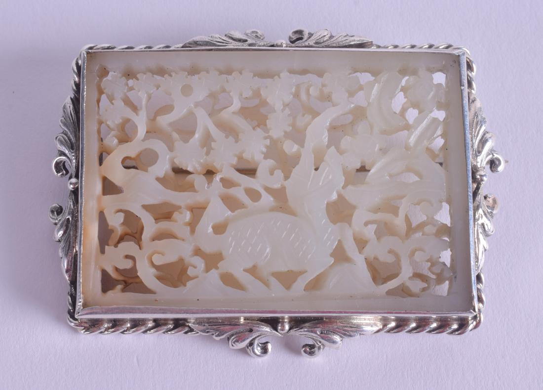 A GOOD 18TH CENTURY CHINESE GREENISH WHITE JADE PLAQUE: A GOOD 18TH CENTURY CHINESE GREENISH WHITE JADE PLAQUE Qianlong, contained within a silver frame, carved with a buddhistic lion. Jade 6 cm x 4 cm.
