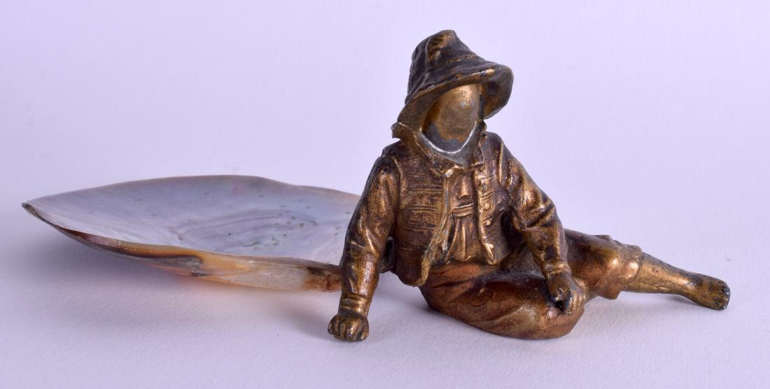 A LATE CENTURY COLD PAINTED SPELTER FIGURAL DISH: A LATE CENTURY COLD PAINTED SPELTER FIGURAL DISH modelled as a seated male beside a shell. 13.5 cm wide.