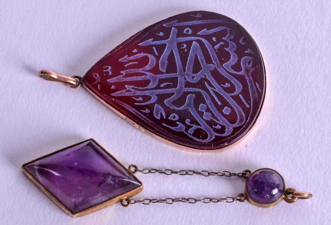 AN ISLAMIC GOLD PENDANT together with a matching: AN ISLAMIC GOLD PENDANT together with a matching amethyst pendant. (2)
