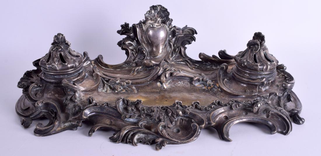 AN EARLY 19TH CENTURY FRENCH SILVERED BRONZE INKWELL of: AN EARLY 19TH CENTURY FRENCH SILVERED BRONZE INKWELL of scrolling rococo form. 42 cm x 20 cm.