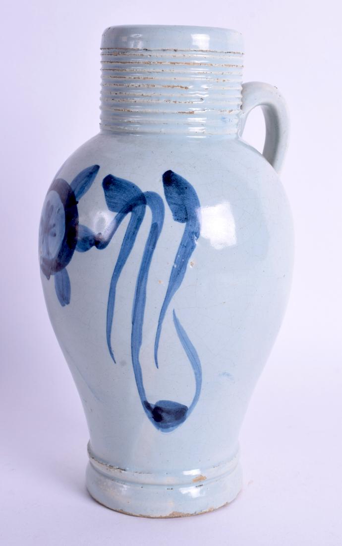 AN 18TH CENTURY DELFT FAIENCE TIN GLAZED FLAGON painted: AN 18TH CENTURY DELFT FAIENCE TIN GLAZED FLAGON painted with a stylised flower. 18 cm high.
