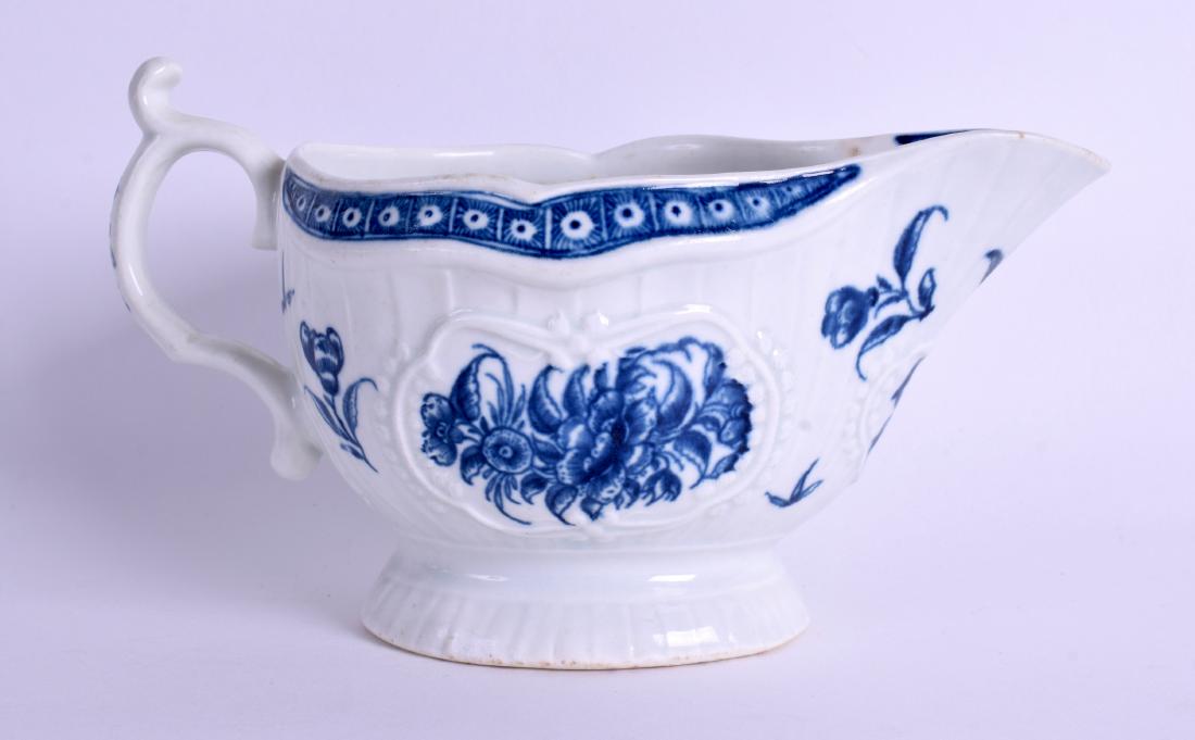 AN 18TH CENTURY WORCESTER BLUE AND WHITE MOULDED: AN 18TH CENTURY WORCESTER BLUE AND WHITE MOULDED SAUCEBOAT painted with flowers and an interior spray. 19 cm wide.