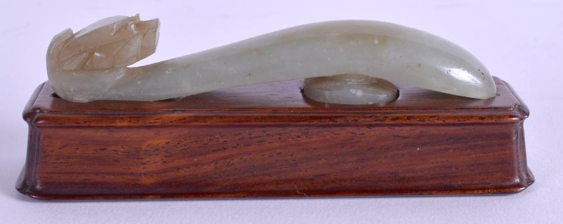 A 19TH CENTURY CHINESE CARVED JADE BELT HOOK Qing,: A 19TH CENTURY CHINESE CARVED JADE BELT HOOK Qing, modelled upon a hongmu base. Jade 8.5 cm long.
