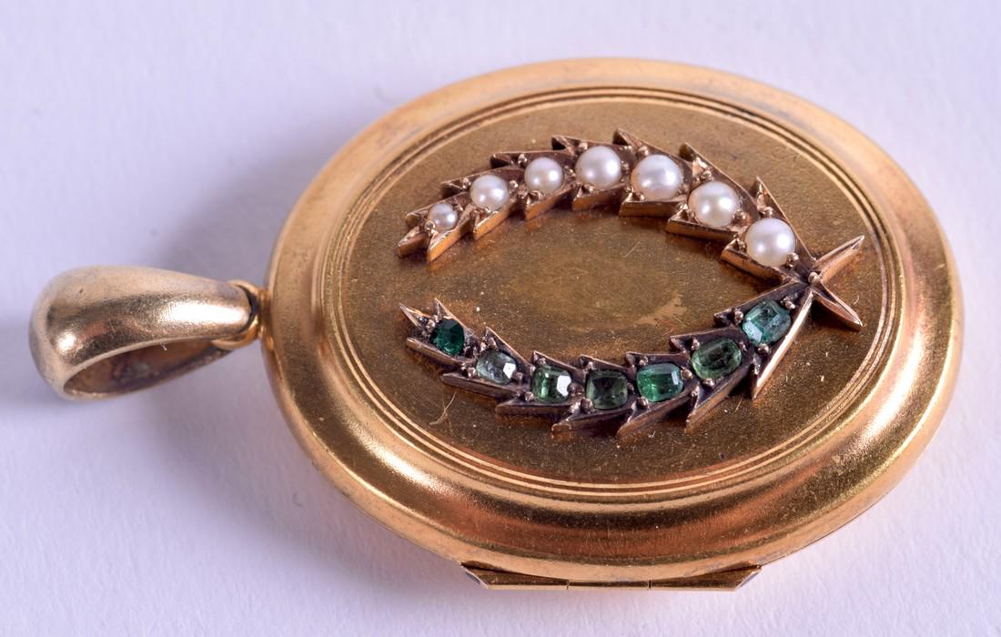 AN ANTIQUE 15CT GOLD PEARL AND EMERALD LOCKET. 11.2: AN ANTIQUE 15CT GOLD PEARL AND EMERALD LOCKET. 11.2 grams. 3 cm x 2.5 cm.