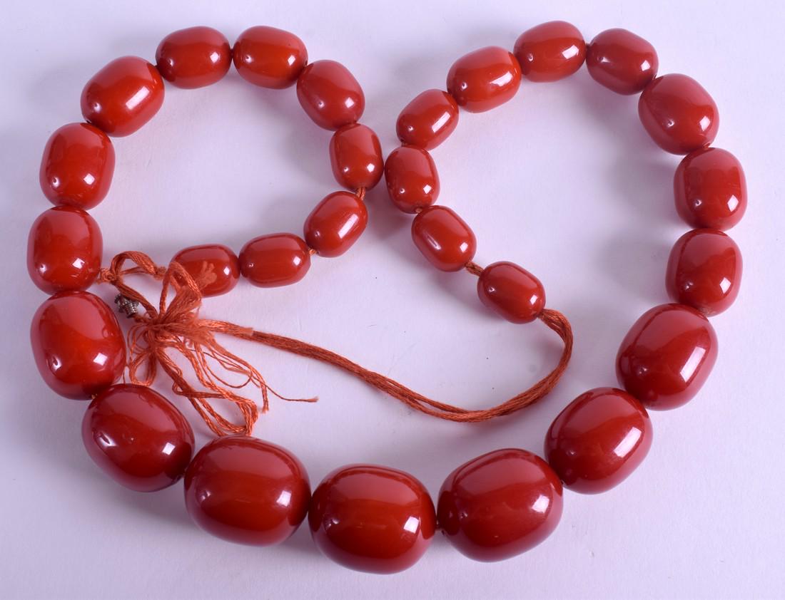AN EARLY 20TH CENTURY TWENTY SEVEN BEAD CHERRY CATALIN: AN EARLY 20TH CENTURY TWENTY SEVEN BEAD CHERRY CATALIN BAKELITE NECKLACE of graduated form. 127 grams. 60 cm long, largest bead 2.5 cm x 2 cm.