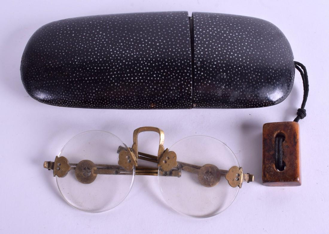 A MID 19TH CENTURY CHINESE BLACK LACQUER IMITATION: A MID 19TH CENTURY CHINESE BLACK LACQUER IMITATION SHAGREEN SPECTACLE CASE containing spectacles. 17 cm long. (2)