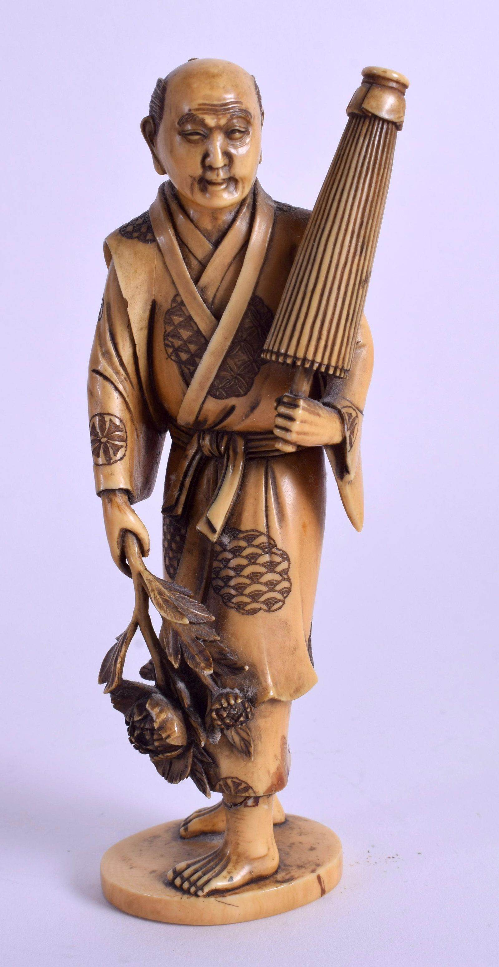A 19TH CENTURY JAPANESE MEIJI PERIOD CARVED OKIMONO: A 19TH CENTURY JAPANESE MEIJI PERIOD CARVED OKIMONO modelled holding a parasol. 16.5 cm high.