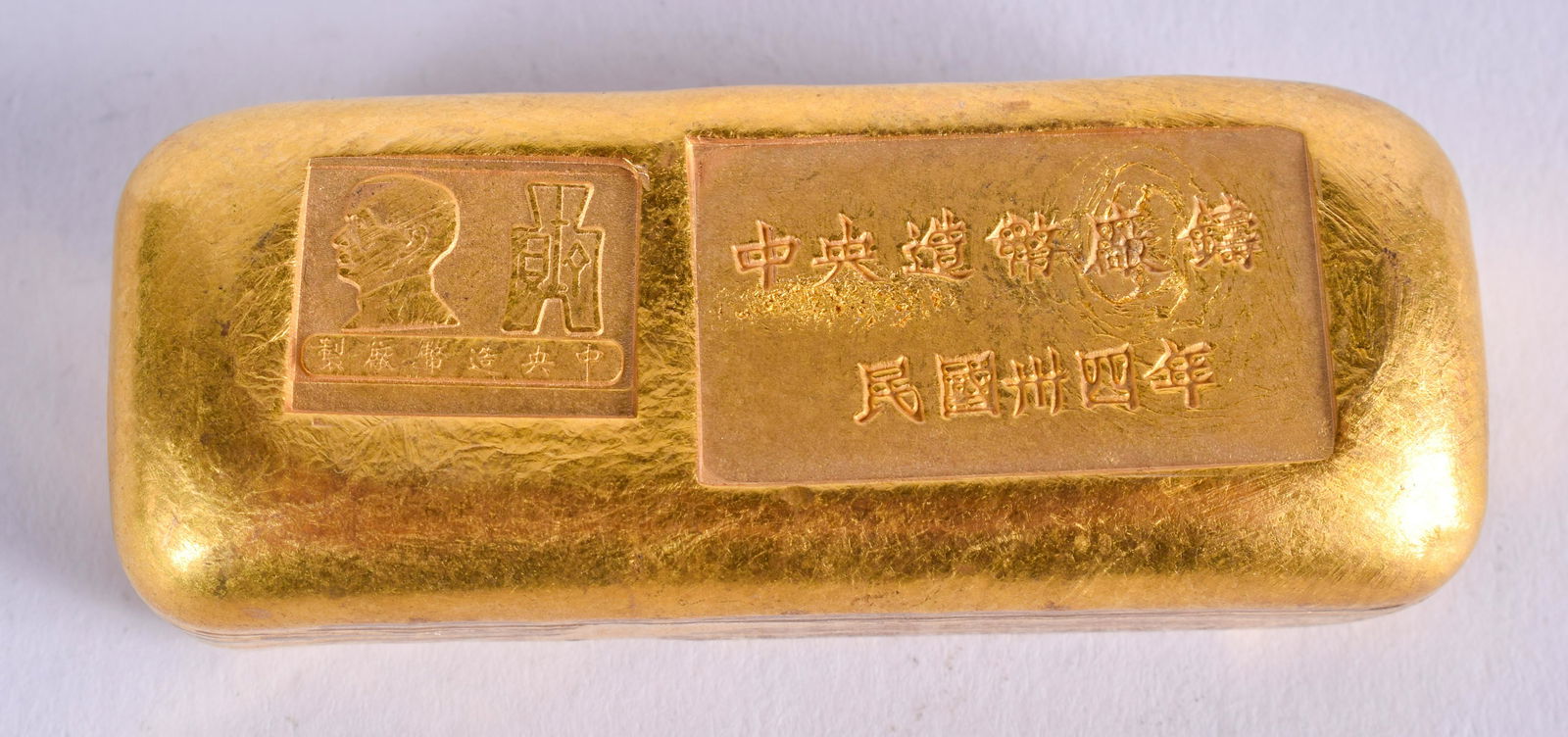 A CHINESE YELLOW METAL INGOT. 185 grams. 6 cm x 2.5 cm. (1 of 3)