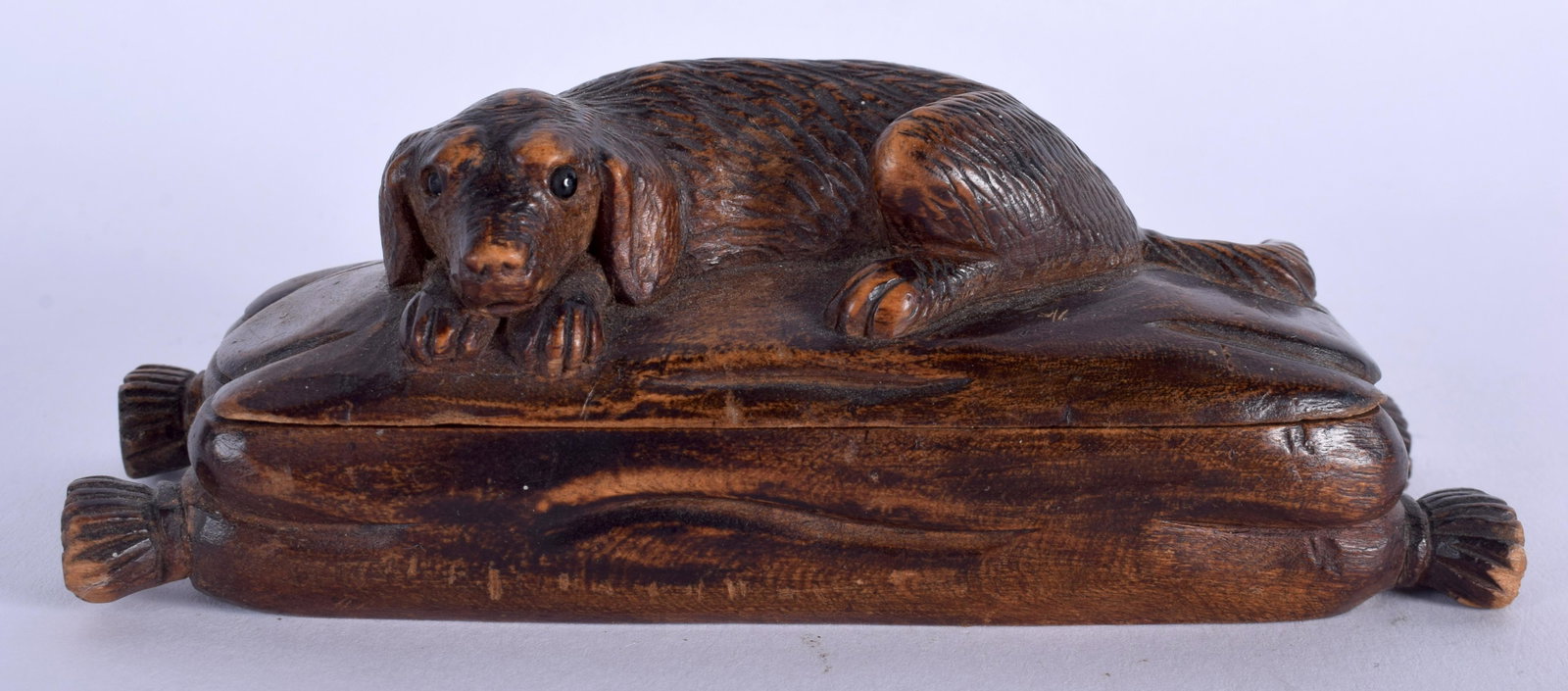 A 19TH CENTURY BAVARIAN BLACK FOREST HOUND SNUFF BOX: A 19TH CENTURY BAVARIAN BLACK FOREST HOUND SNUFF BOX modelled recumbent with glass eyes. 13 cm wide.