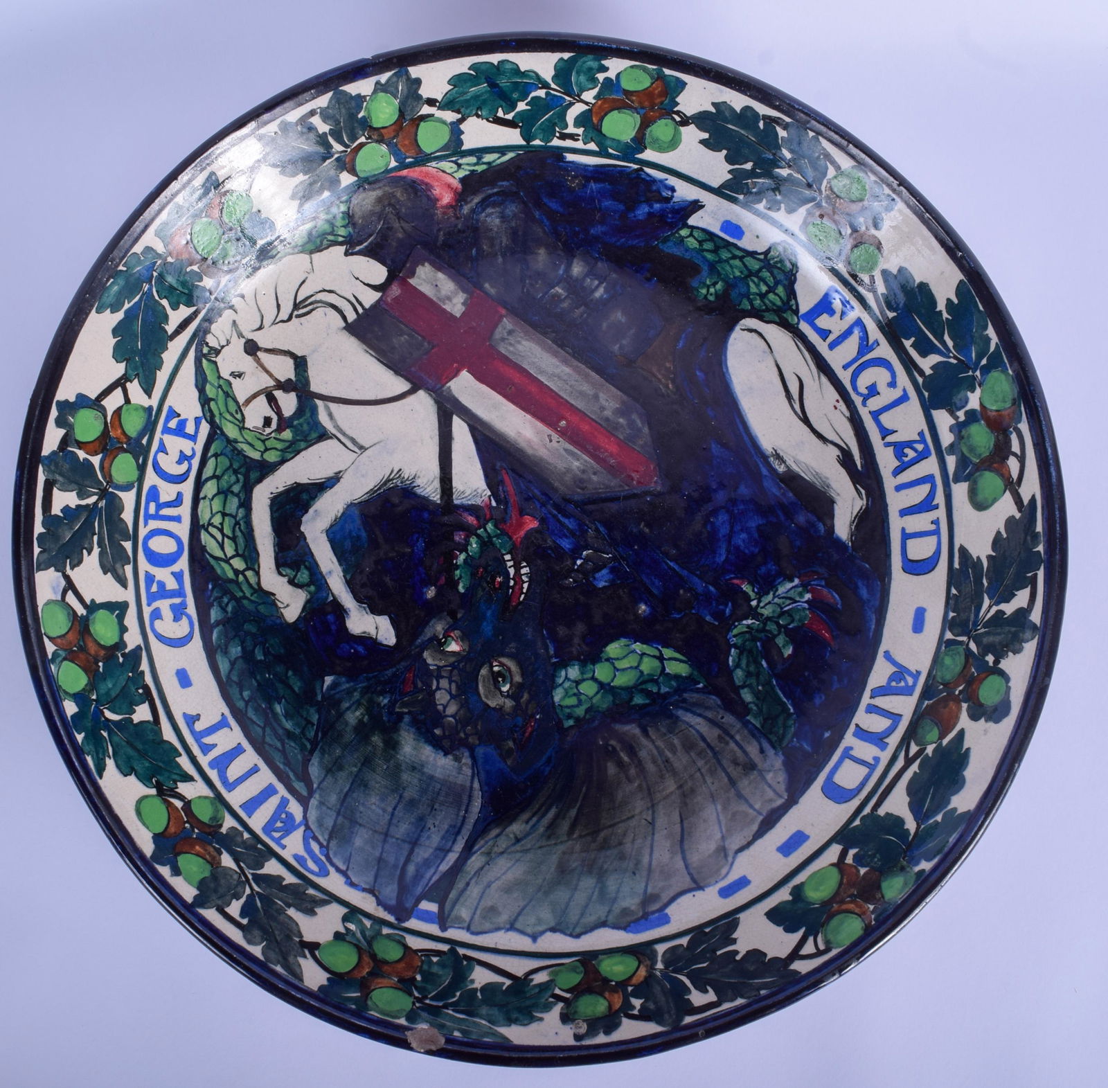 A RARE LARGE ARTS AND CRAFTS POTTERY CHARGER In the: A RARE LARGE ARTS AND CRAFTS POTTERY CHARGER In the manner of William De Morgan, painted with Saint George & the Dragon. 38 cm diameter.