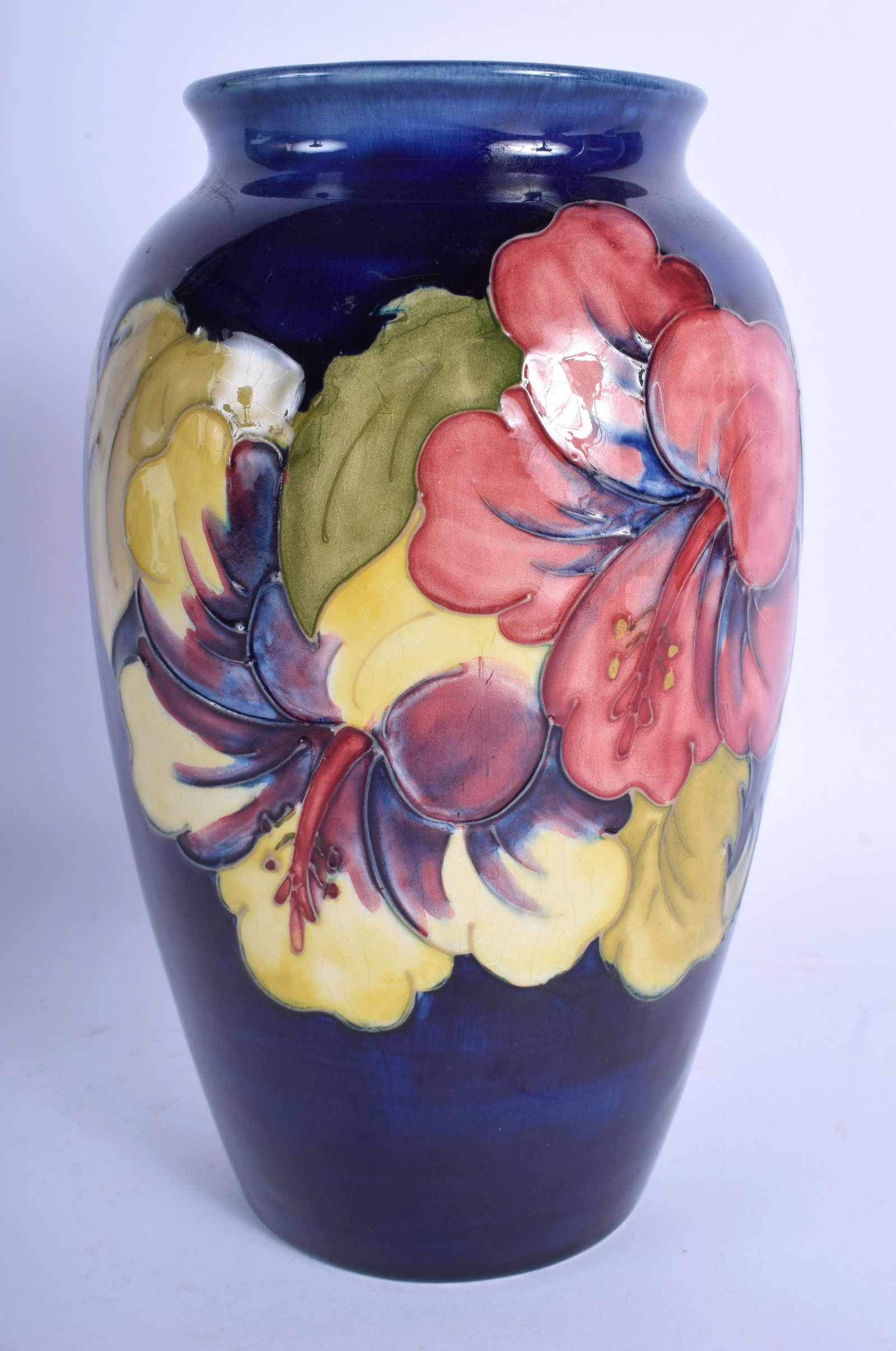 A WILLIAM MOORCROFT POWDER BLUE VASE decorated with: A WILLIAM MOORCROFT POWDER BLUE VASE decorated with foliage. 21.5 cm high.