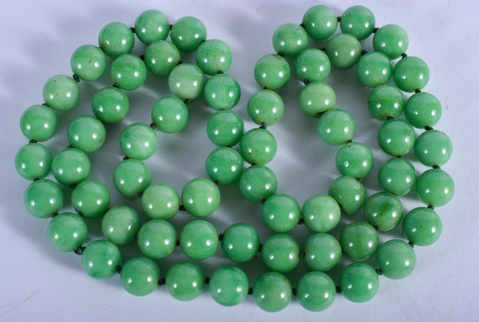 A LARGE 1920S CHINESE CARVED JADEITE NECKLACE. 86 cm: A LARGE 1920S CHINESE CARVED JADEITE NECKLACE. 86 cm long.
