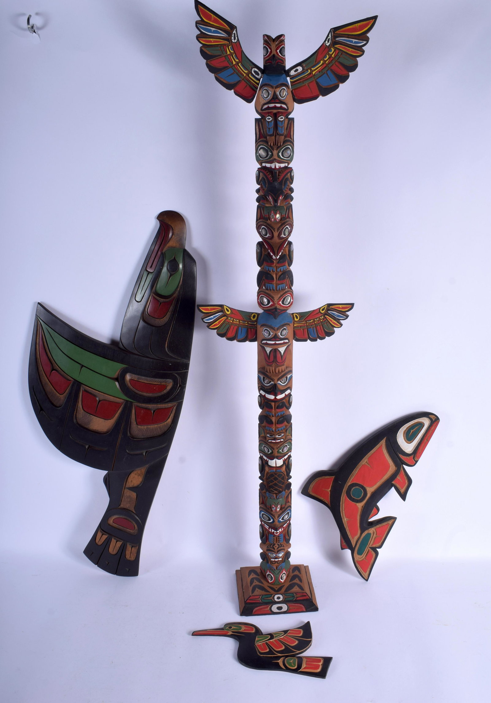 A CANADIAN NORTHER AMERICAN HAIDA TRIBAL CARVED FLYING: A CANADIAN NORTHER AMERICAN HAIDA TRIBAL CARVED FLYING EAGLE together with two others and a totem, including Dann Lewis, Doug Harper etc. (4)