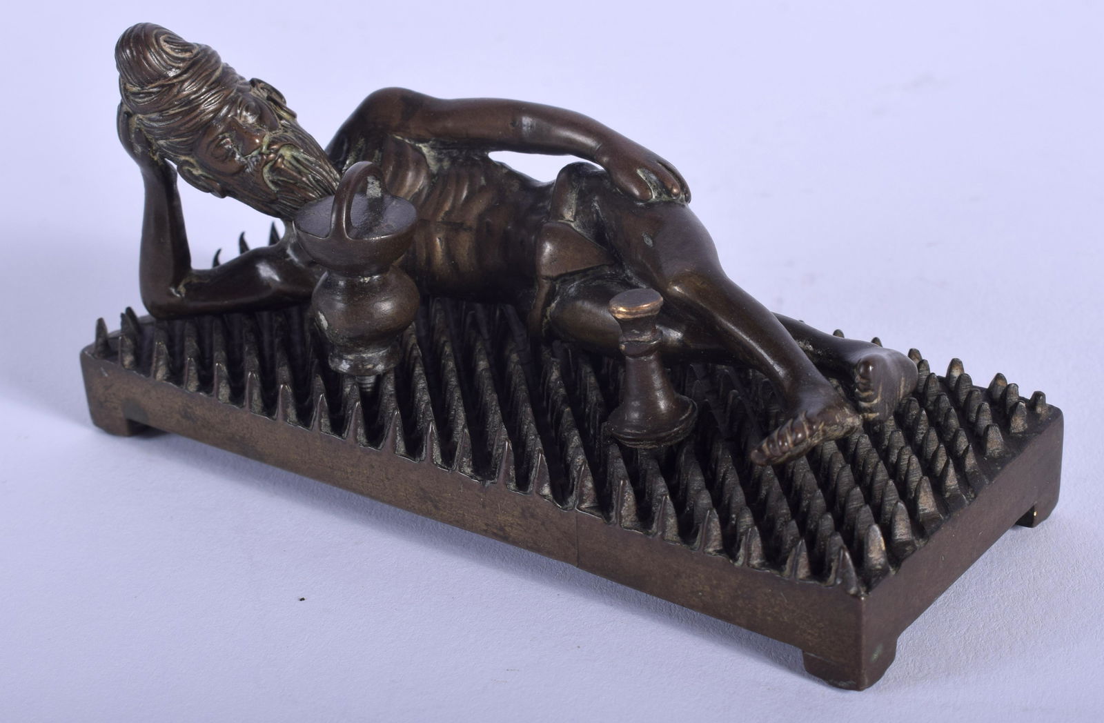 A RARE 19TH CENTURY INDIAN BRONZE FIGURE OF AN: A RARE 19TH CENTURY INDIAN BRONZE FIGURE OF AN EMACIATED BUDDHA modelled upon a spikey base. 11.5 cm x 4.5 cm.