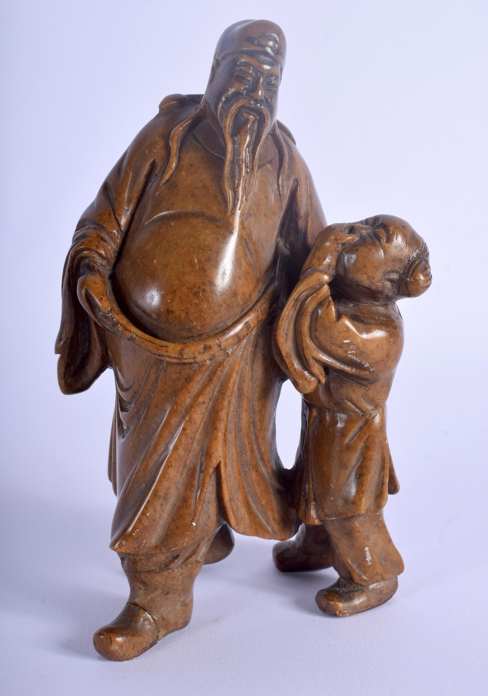 A 19TH CENTURY CHINESE SOAPSTONE FIGURE OF A SCHOLAR: A 19TH CENTURY CHINESE SOAPSTONE FIGURE OF A SCHOLAR modelled beside a child. 14 cm x 5 cm.