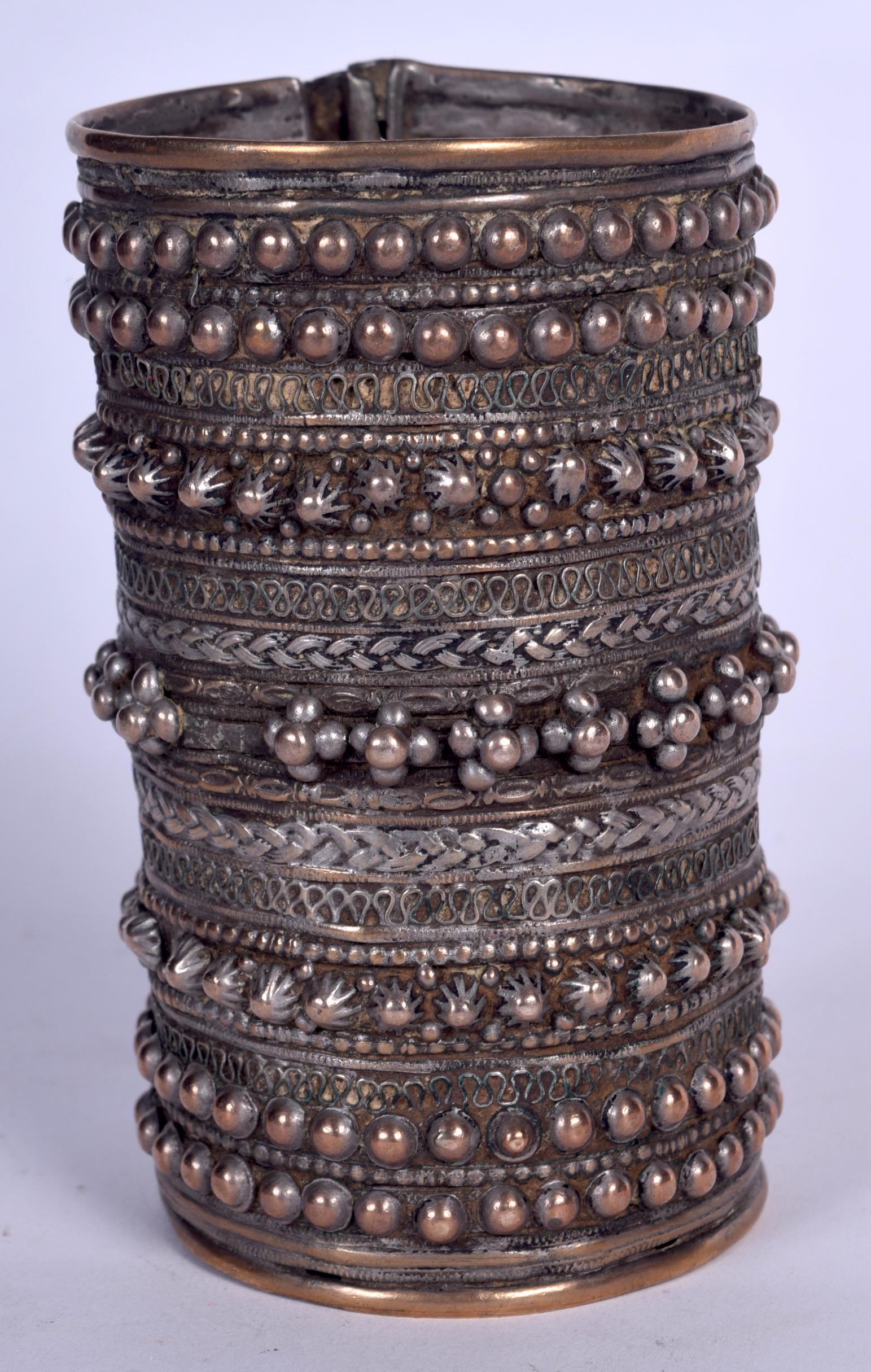 A MIDDLE EASTERN WHITE METAL BANGLE, decorated with (1 of 1)