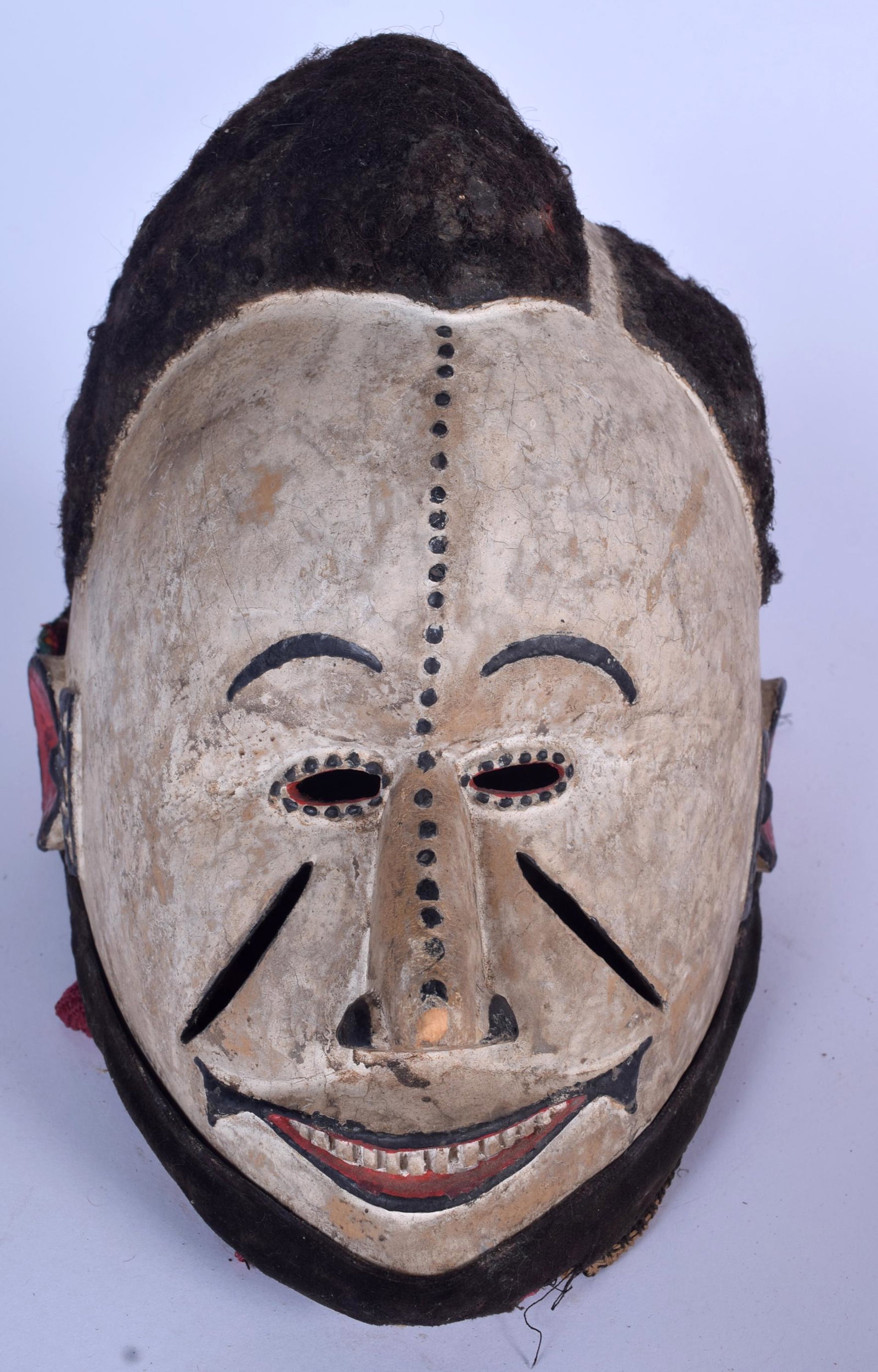 A GOOD NIGERIAN IBIBIO WOODEN POLYCHROMED GELEDE MASK,: A GOOD NIGERIAN IBIBIO WOODEN POLYCHROMED GELEDE MASK, formed with wool like hair and cloth neck piece. 24 cm x 17 cm.