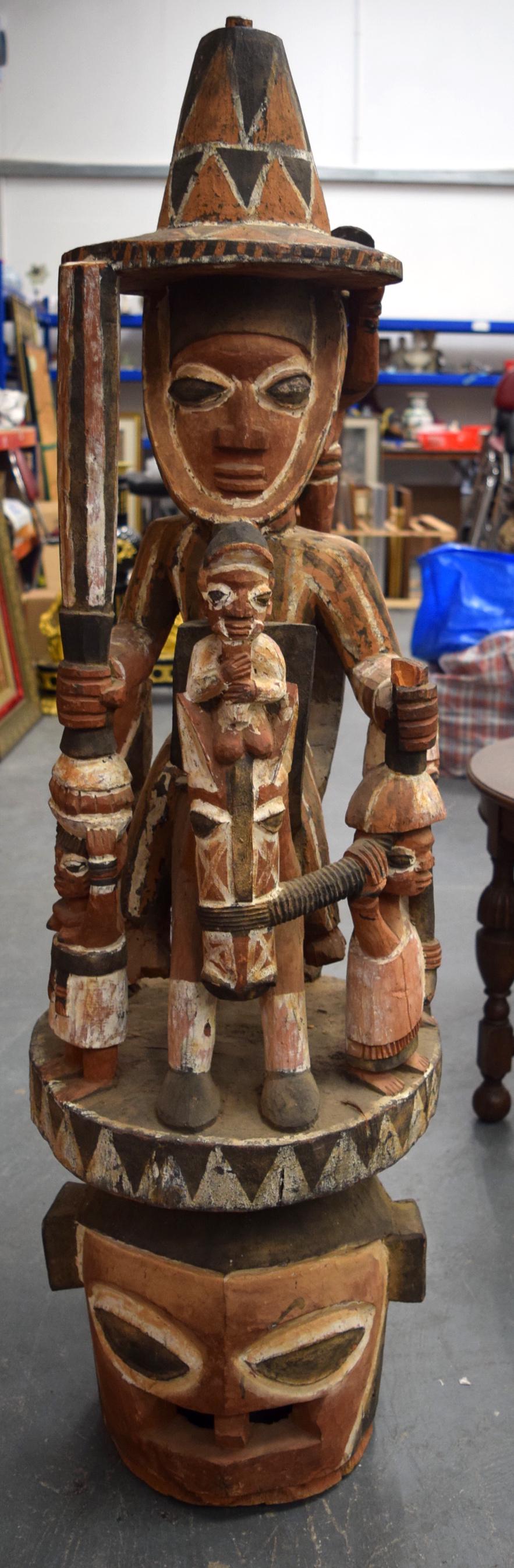 A LARGE NIGERIAN YORUBA POLYCHROMED WOODEN STATUE,: A LARGE NIGERIAN YORUBA POLYCHROMED WOODEN STATUE, formed as a standing figure with attendants in various pursuits. 127 cm high.