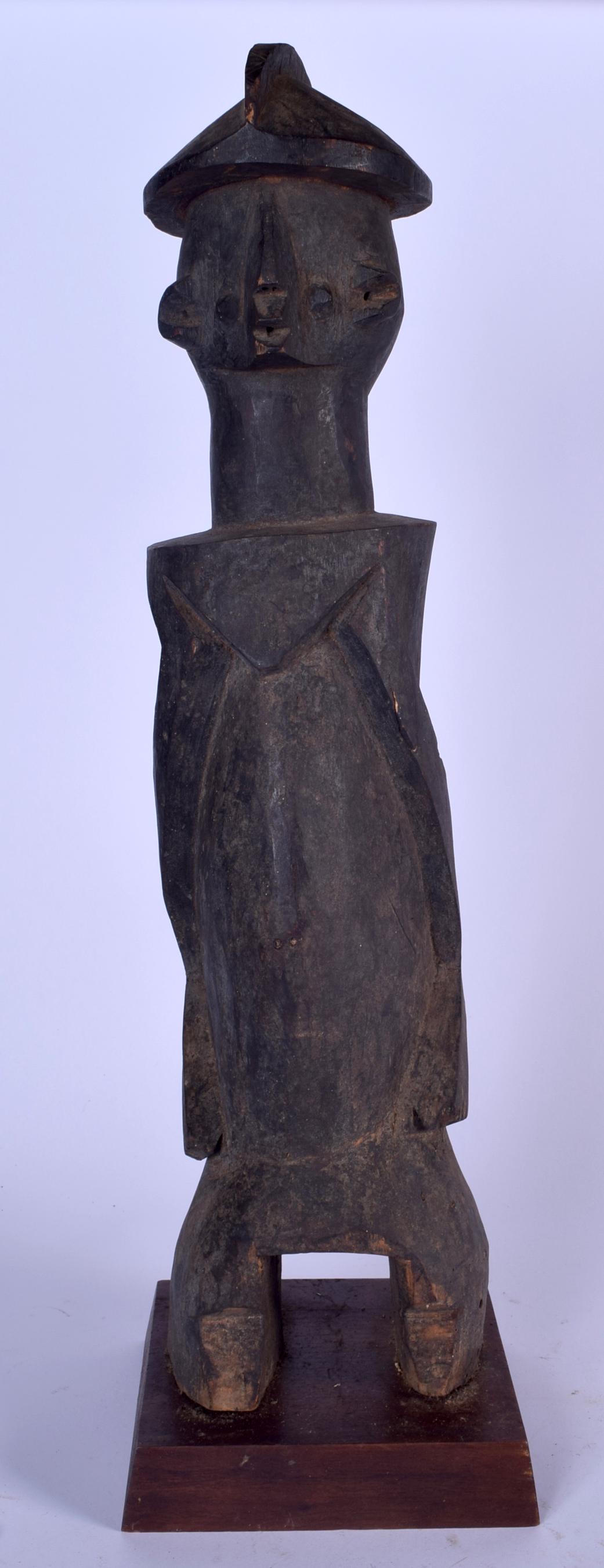 A LARGE AFRICAN CARVED WOODEN STATUE, formed upon a (1 of 2)
