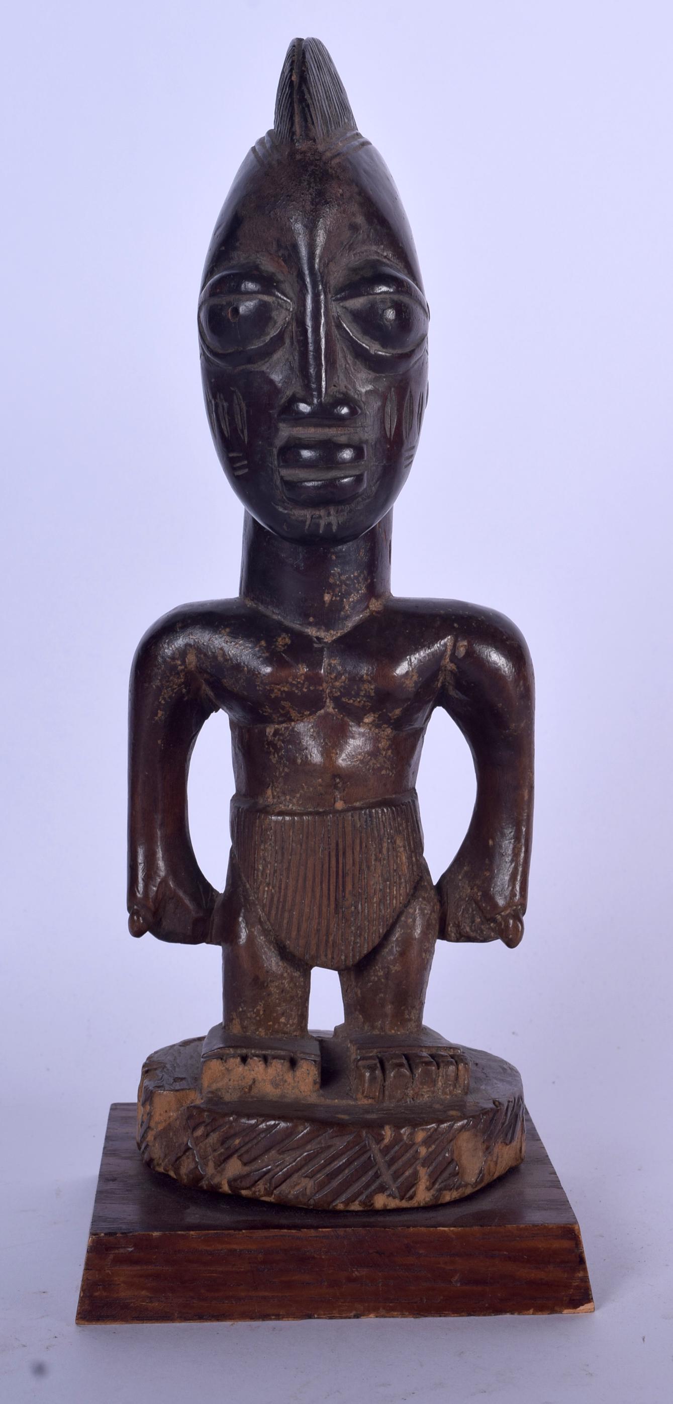 A NIGERIAN YORUBA CARVED WOODEN STATUE, formed as a: A NIGERIAN YORUBA CARVED WOODEN STATUE, formed as a standing figure. 32 cm high.