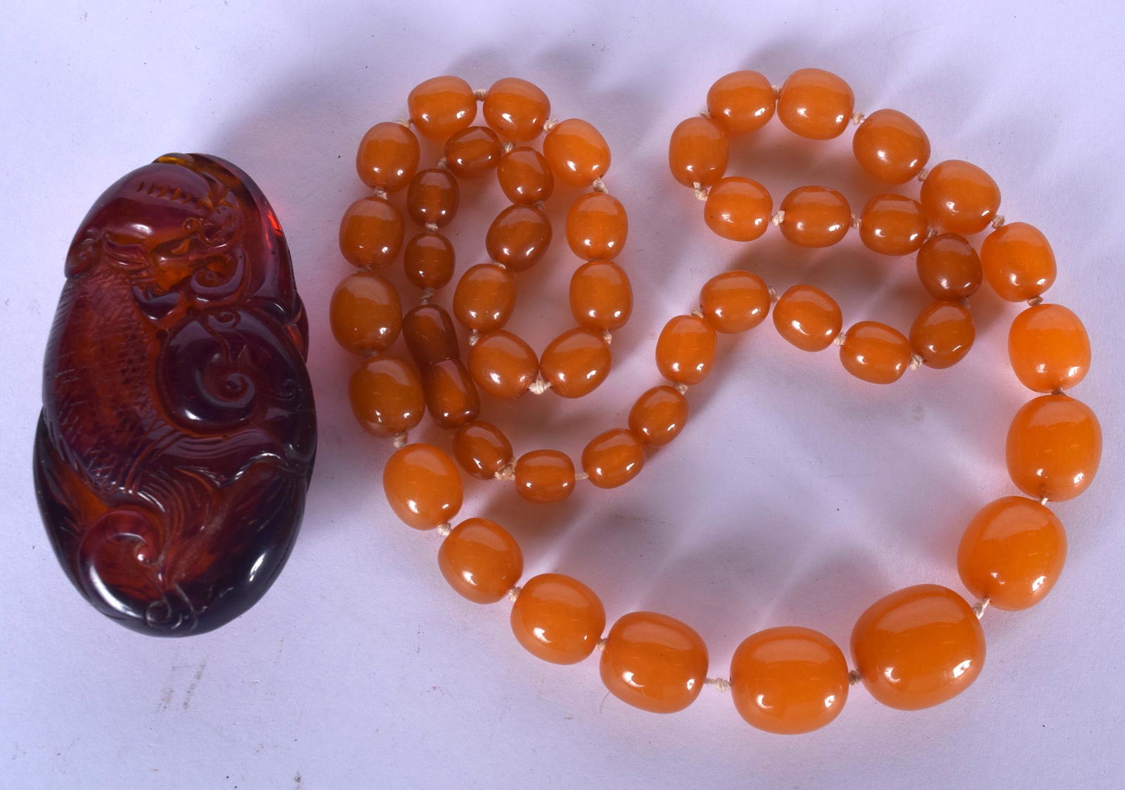 AN AMBER TYPE NECKLACE, together with a boulder. (1 of 1)