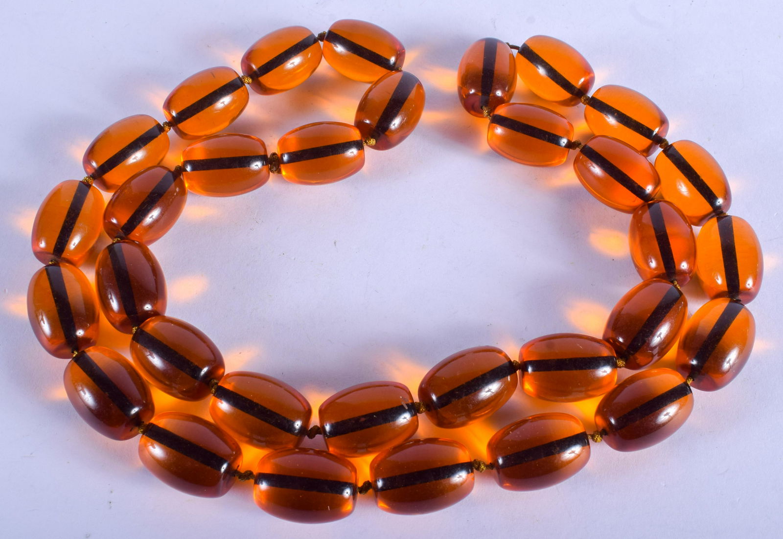 A STRING OF AMBER. 84 cm long. (1 of 2)