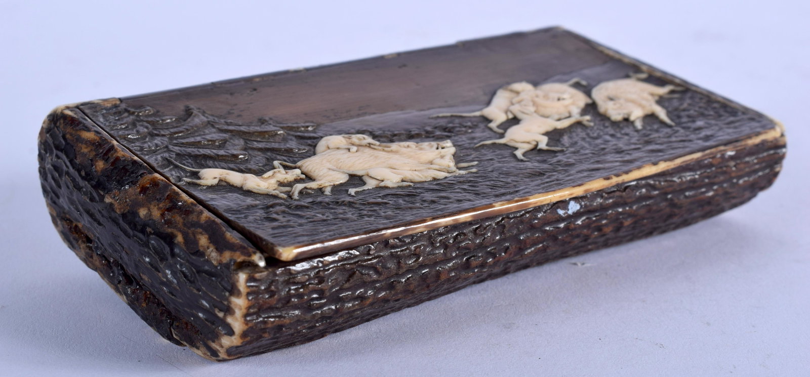A 19TH CENTURY BAVARIAN BLACK FOREST CARVED BONE AND: A 19TH CENTURY BAVARIAN BLACK FOREST CARVED BONE AND STAG ANTLER SNUFF BOX decorated with dogs pursuing wild boer. 12.5 cm x 7 cm.