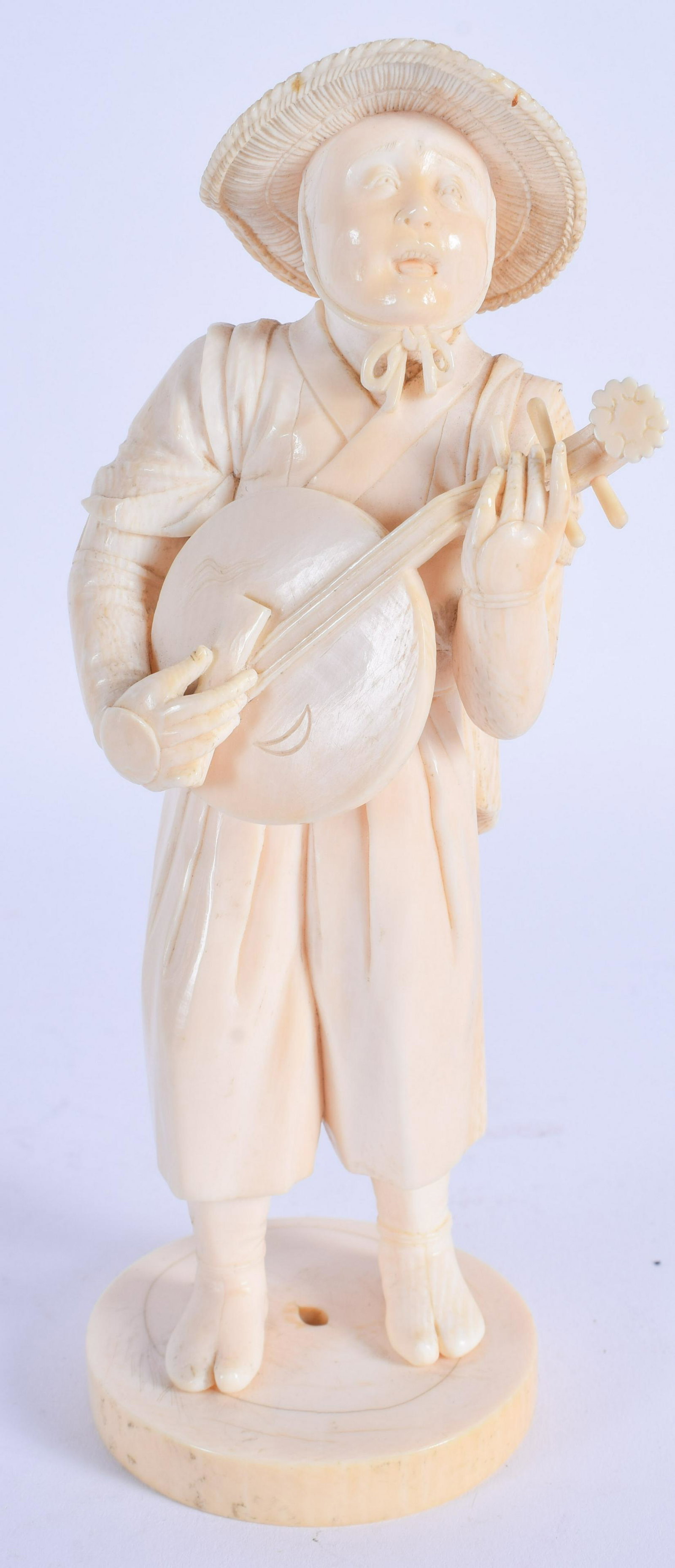 A 19TH CENTURY JAPANESE MEIJI PERIOD CARVED BONE: A 19TH CENTURY JAPANESE MEIJI PERIOD CARVED BONE OKIMONO modelled as a musician. 18 cm high.