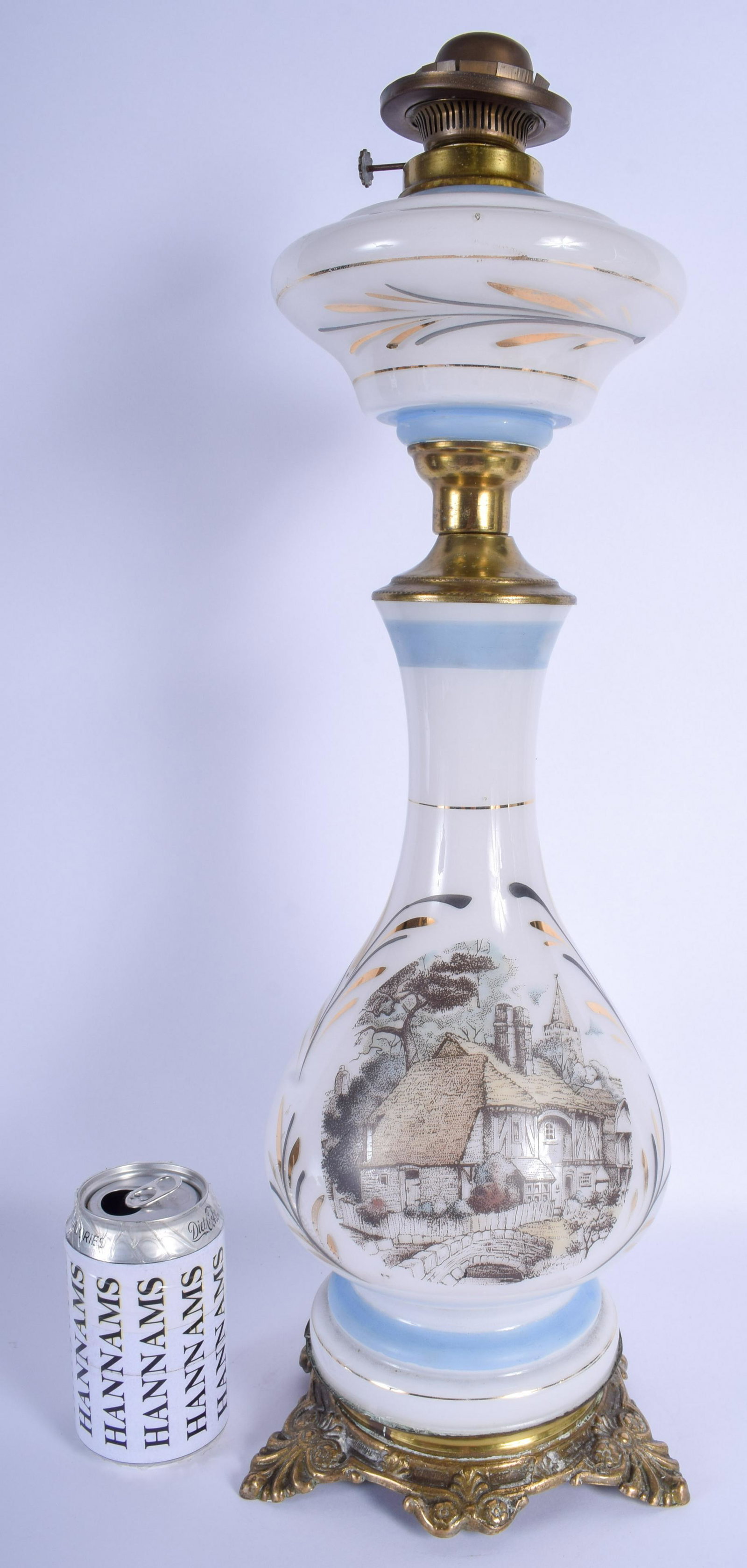 A VINTAGE OPALINE GLASS OIL LAMP decorated with: A VINTAGE OPALINE GLASS OIL LAMP decorated with buildings. 50 cm high.