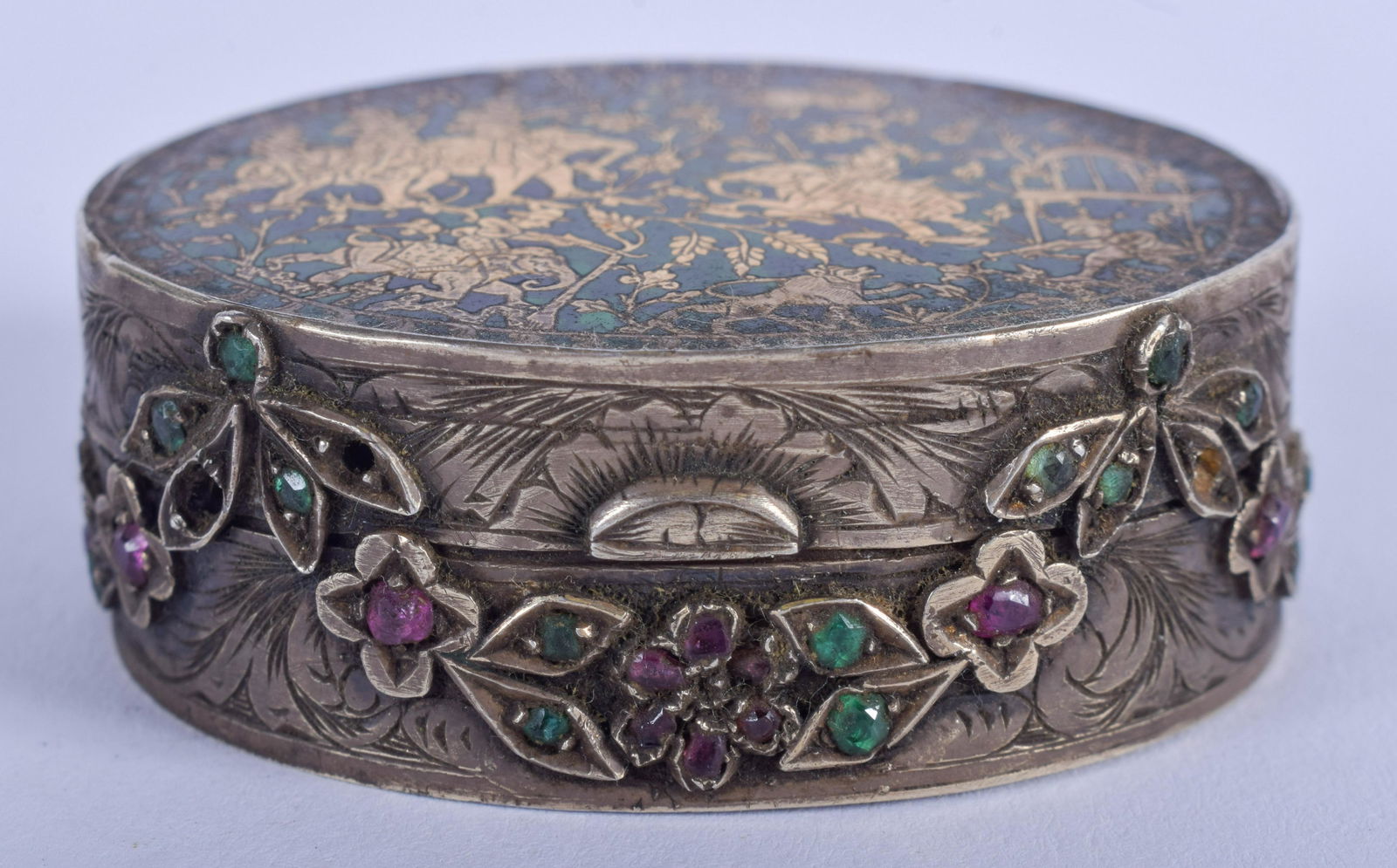 A 19TH CENTURY INDIAN SILVER ENAMEL RUBY AND EMERALD: A 19TH CENTURY INDIAN SILVER ENAMEL RUBY AND EMERALD PILL BOX decorated with hunting scenes. 5 cm wide.