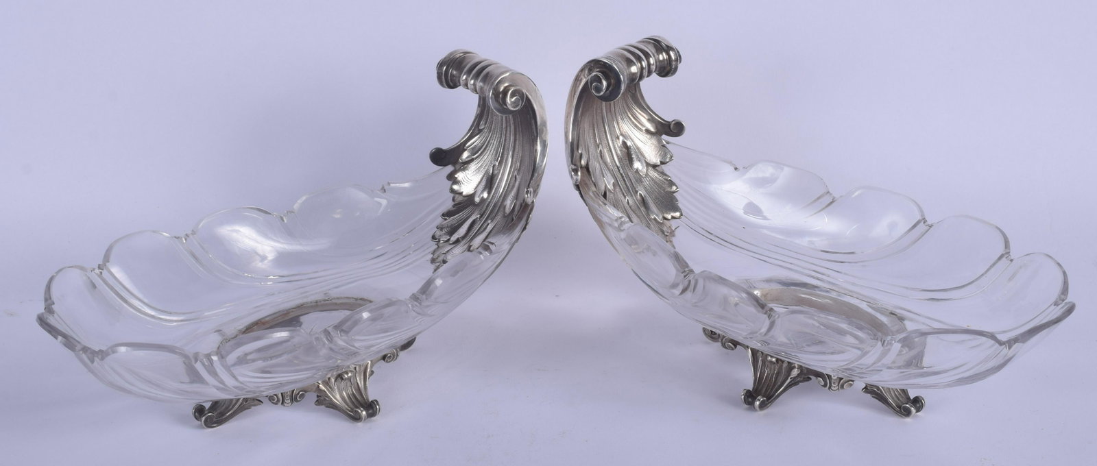 A LOVELY PAIR OF 19TH CENTURY FRENCH SILVER AND CRYSTAL: A LOVELY PAIR OF 19TH CENTURY FRENCH SILVER AND CRYSTAL GLASS SWEETMEAT DISHES of scrolling form. 21 cm x 12 cm.