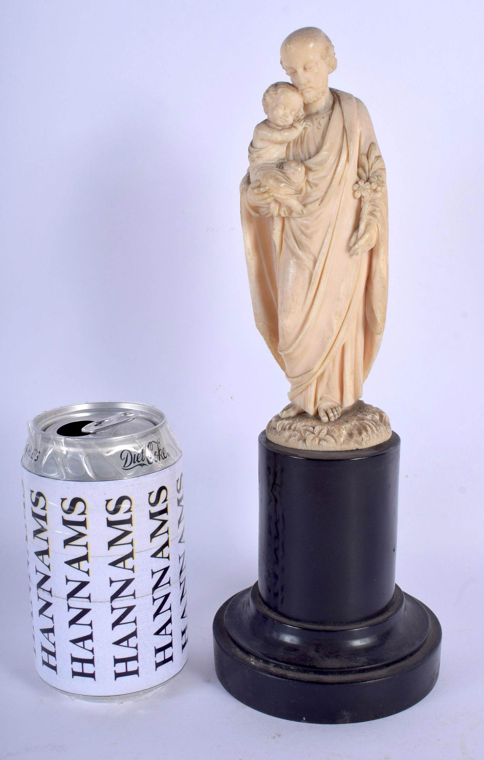 A 19TH CENTURY EUROPEAN CARVED bone FIGURE OF A S: A 19TH CENTURY EUROPEAN CARVED bone FIGURE OF A SAINT AND CHILD modelled upon an ebonised base. bone 16 cm high.