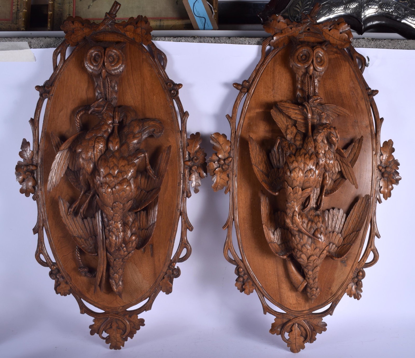 A LARGE PAIR OF 19TH CENTURY BAVARIAN BLACK FOREST: A LARGE PAIR OF 19TH CENTURY BAVARIAN BLACK FOREST HANGING WALL PANELS formed with dead game being held by an owl. 82 cm x 44 cm.