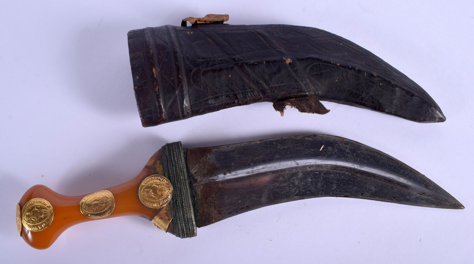 AN ANTIQUE MIDDLE EASTERN AMBER AND GOLD HANDLED: AN ANTIQUE MIDDLE EASTERN AMBER AND GOLD HANDLED JAMBIYA DAGGER. 31 cm long.