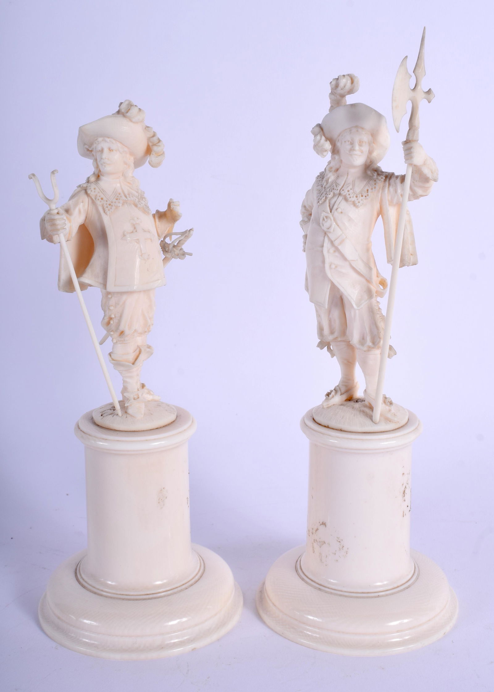 A PAIR OF 19TH CENTURY EUROPEAN CARVED bone DIEPPE: A PAIR OF 19TH CENTURY EUROPEAN CARVED bone DIEPPE FIGURES modelled upon a cylindrical base. 21 cm high.