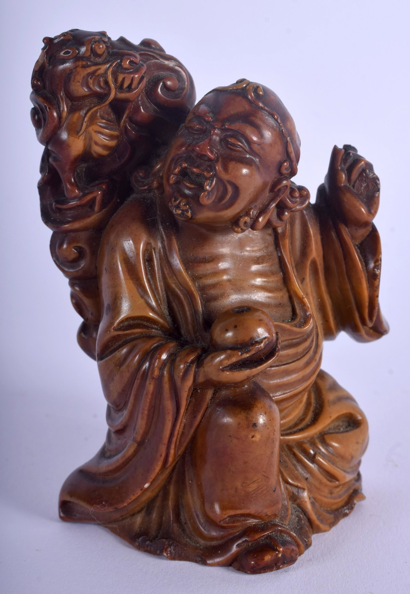 A 19TH CENTURY CHINESE CARVED SOAPSTONE FIGURE OF AN: A 19TH CENTURY CHINESE CARVED SOAPSTONE FIGURE OF AN IMMORTAL Qing, modelled beside a dragon. 9 cm x 5 cm.