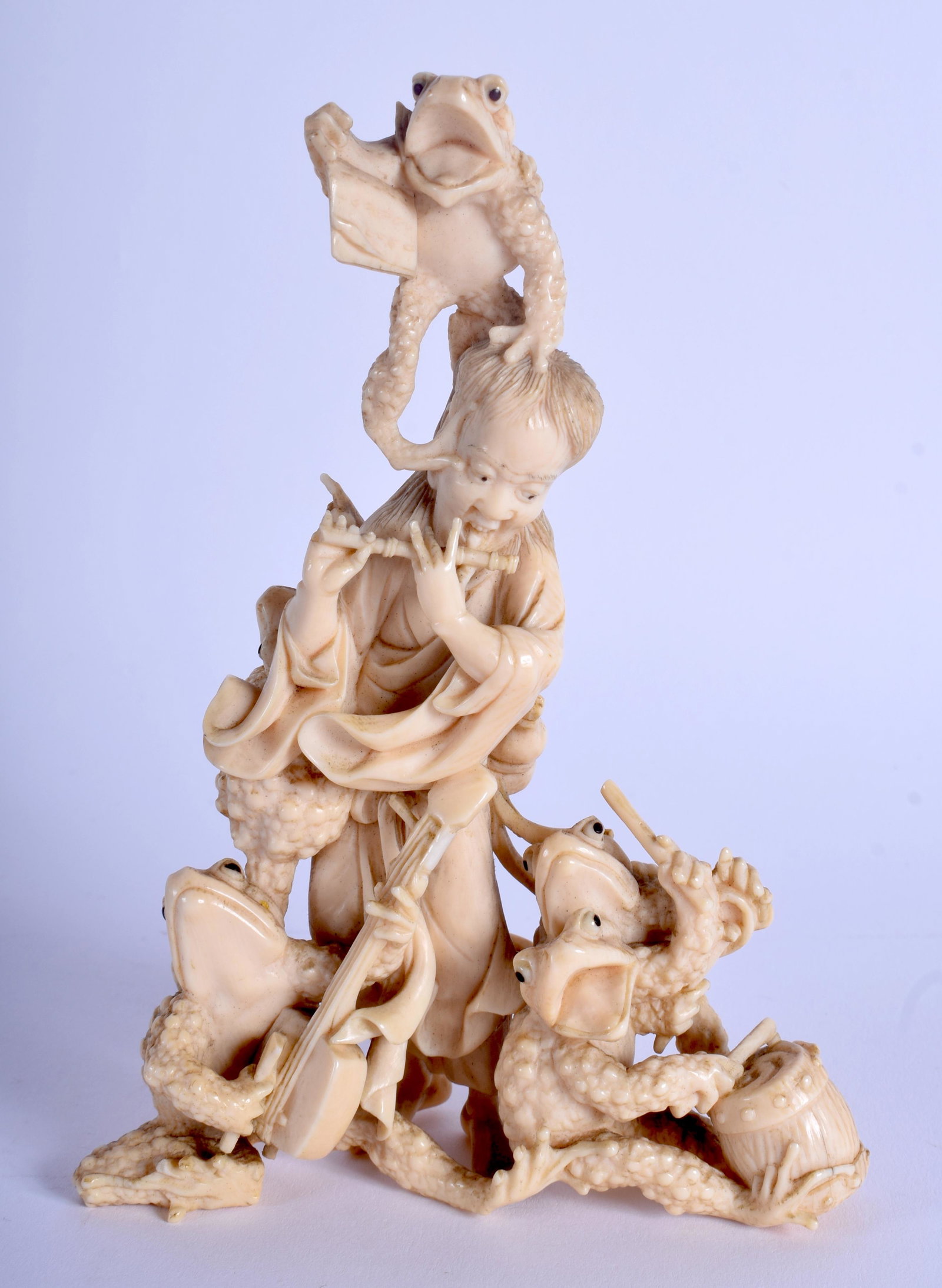 A 19TH CENTURY JAPANESE MEIJI PERIOD CARVED OKIMONO: A 19TH CENTURY JAPANESE MEIJI PERIOD CARVED OKIMONO modelled as a musician performing for a group of toads. 14 cm x 18 cm.