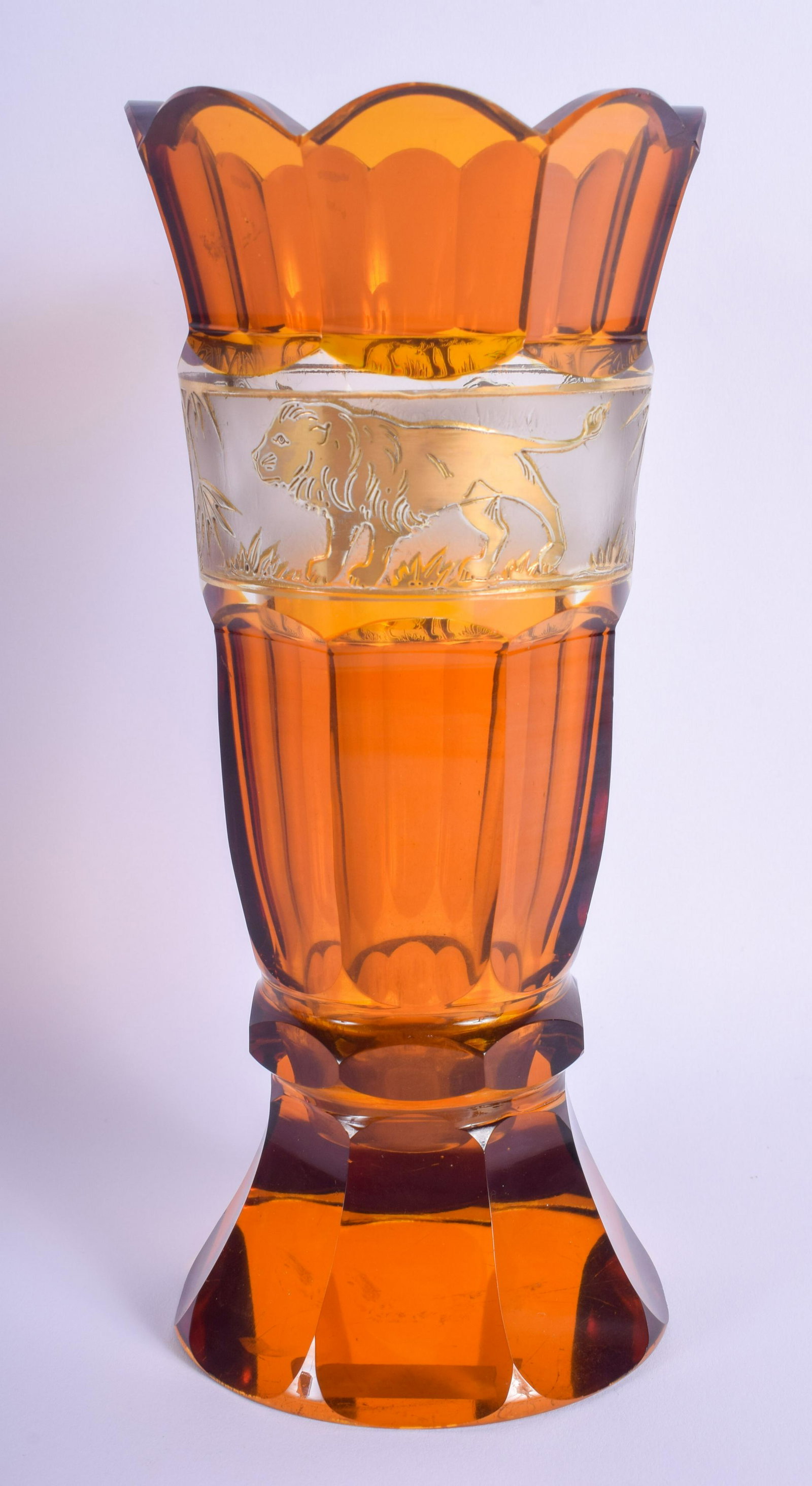 AN ANTIQUE BOHEMIAN AMBER GLASS FLUTED GOBLET VASE: AN ANTIQUE BOHEMIAN AMBER GLASS FLUTED GOBLET VASE possibly Moser, decorated with a banding of lions. 20 cm high.