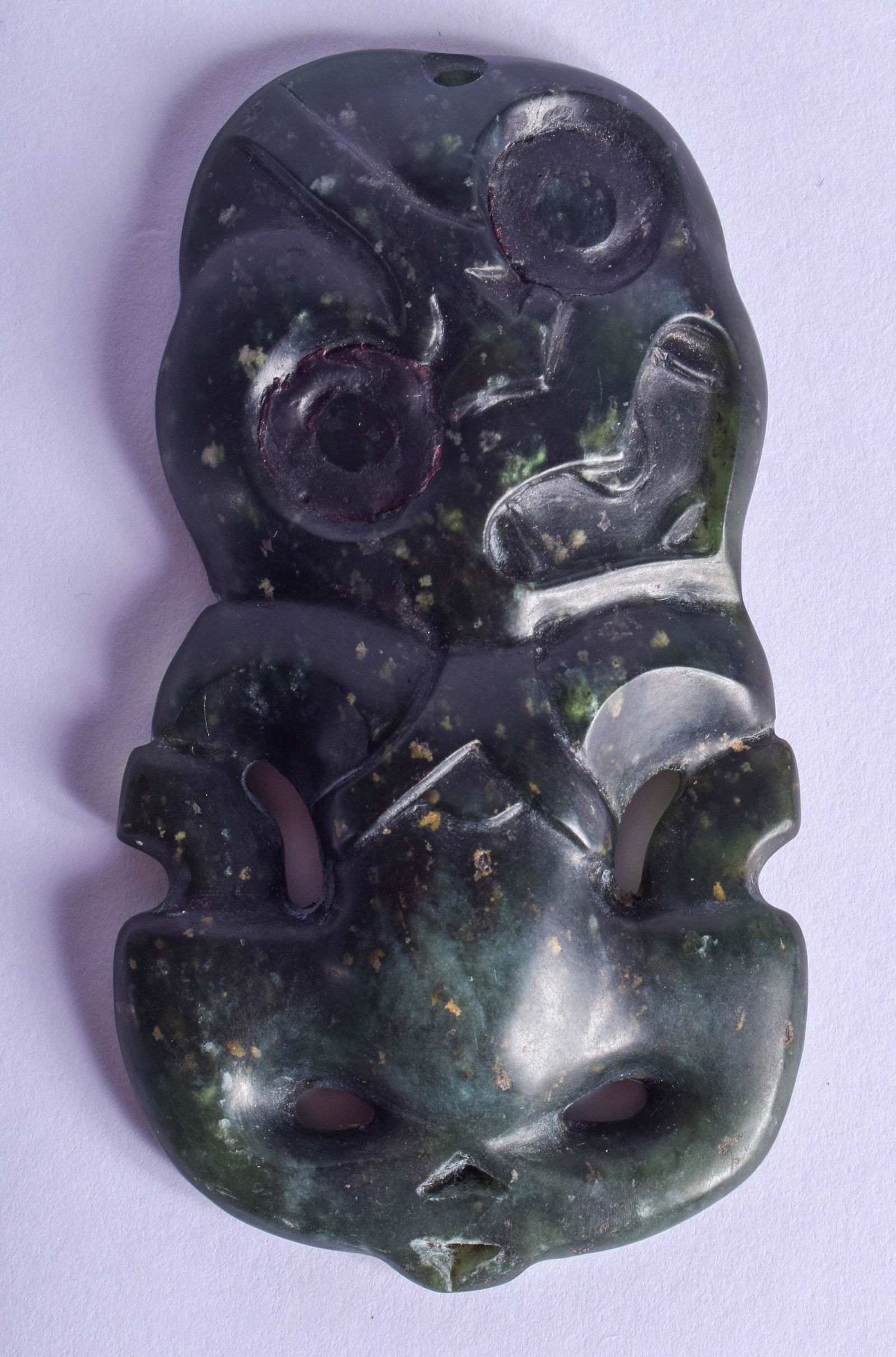 A FINE AND RARE MAORI PENDANT IN HUMAN FORM New: A FINE AND RARE MAORI PENDANT IN HUMAN FORM New Zealand, Hei Tiki, Greenstone/Nephrite Jade (possibly inanga variety pounamu). 8.5 cm x 4.5 cm.