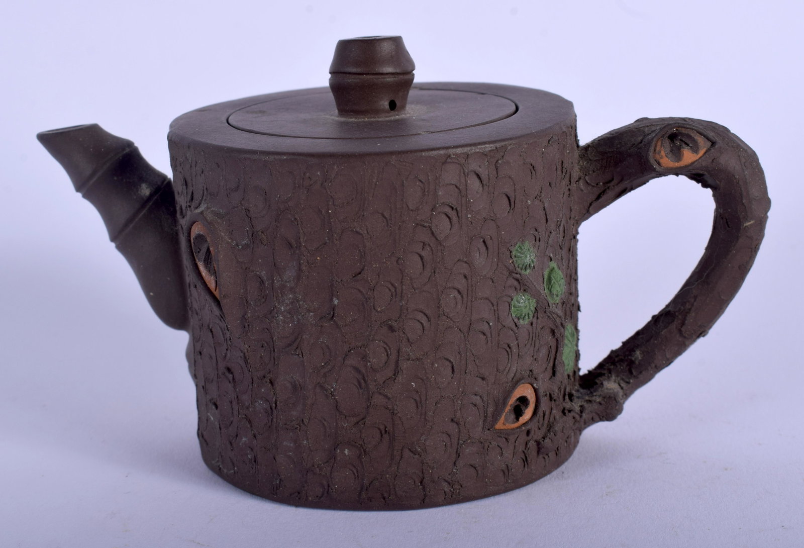 A CHINESE YIXING POTTERY TEAPOT AND COVER 20th century,: A CHINESE YIXING POTTERY TEAPOT AND COVER 20th century, by Zhou Mei Fen Zhi, overlaid with foliage. 11 cm wide.