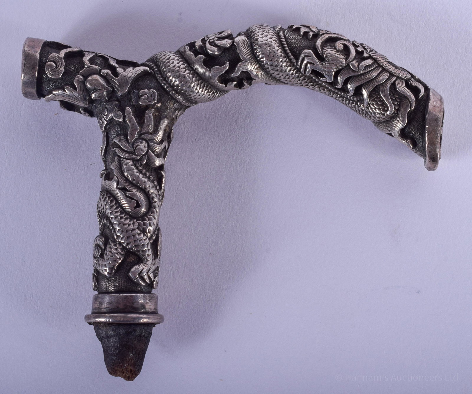 A 19TH CENTURY CHINESE SILVER DRAGON CANE HANDLE: A 19TH CENTURY CHINESE SILVER DRAGON CANE HANDLE decorated with dragons in various pursuits. 115 grams. 9.5 cm x 7 cm.