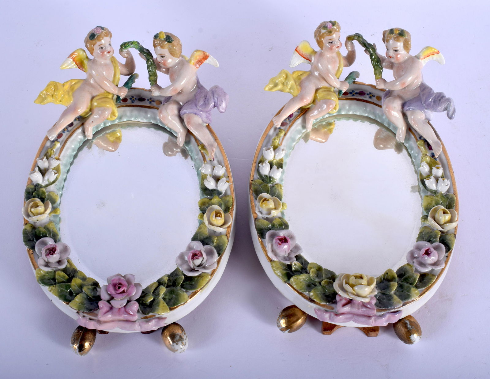 19th c. Sitzendorf pair of table mirrors surmounted by: 19th c. Sitzendorf pair of table mirrors surmounted by winged cherubs. 17cm high