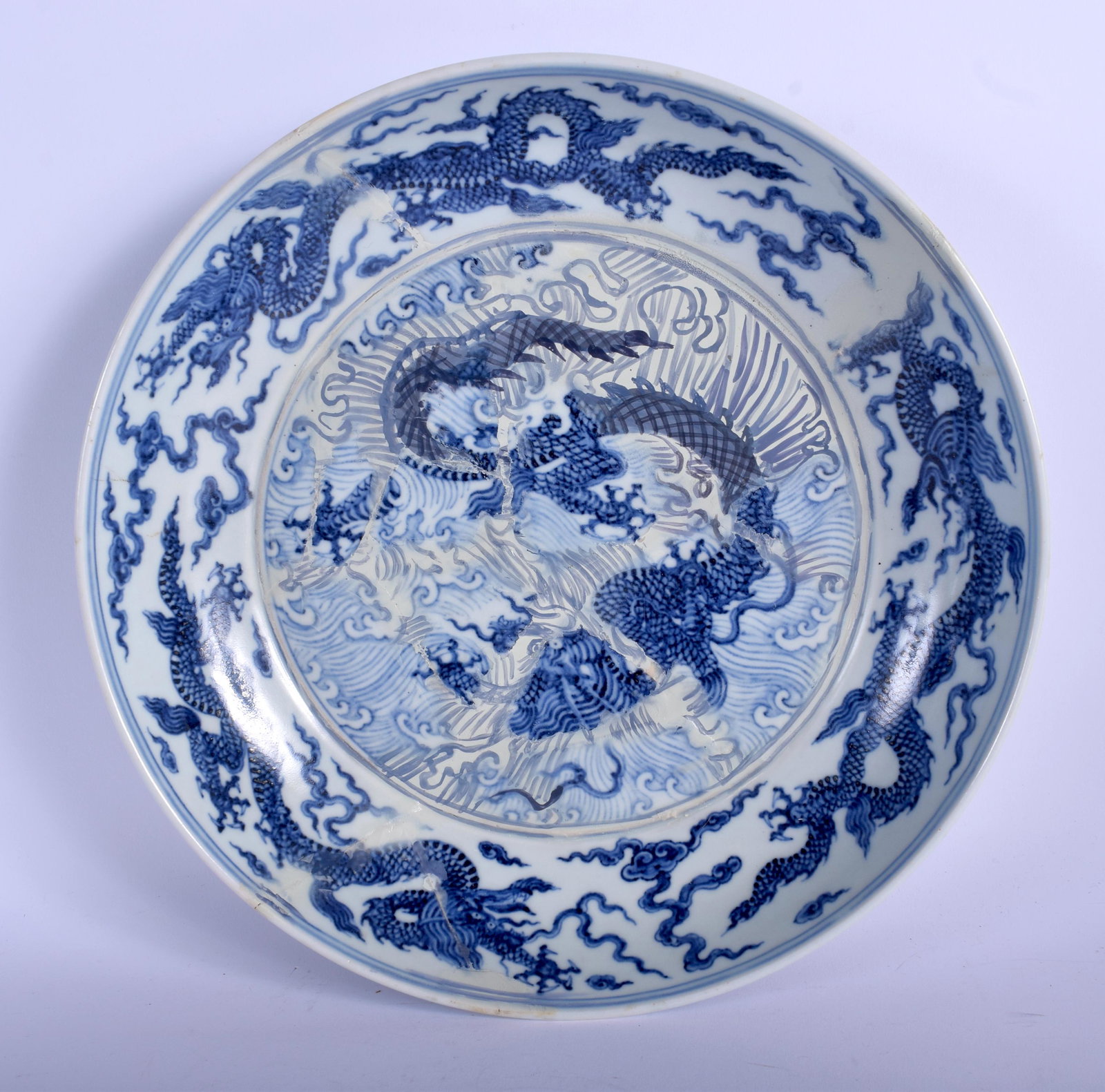 AN 18TH CENTURY CHINESE BLUE AND WHITE PORCELAIN DISH: AN 18TH CENTURY CHINESE BLUE AND WHITE PORCELAIN DISH Qing, bearing Xuande marks to rim, painted with dragons amongst clouds. 29 cm diameter.