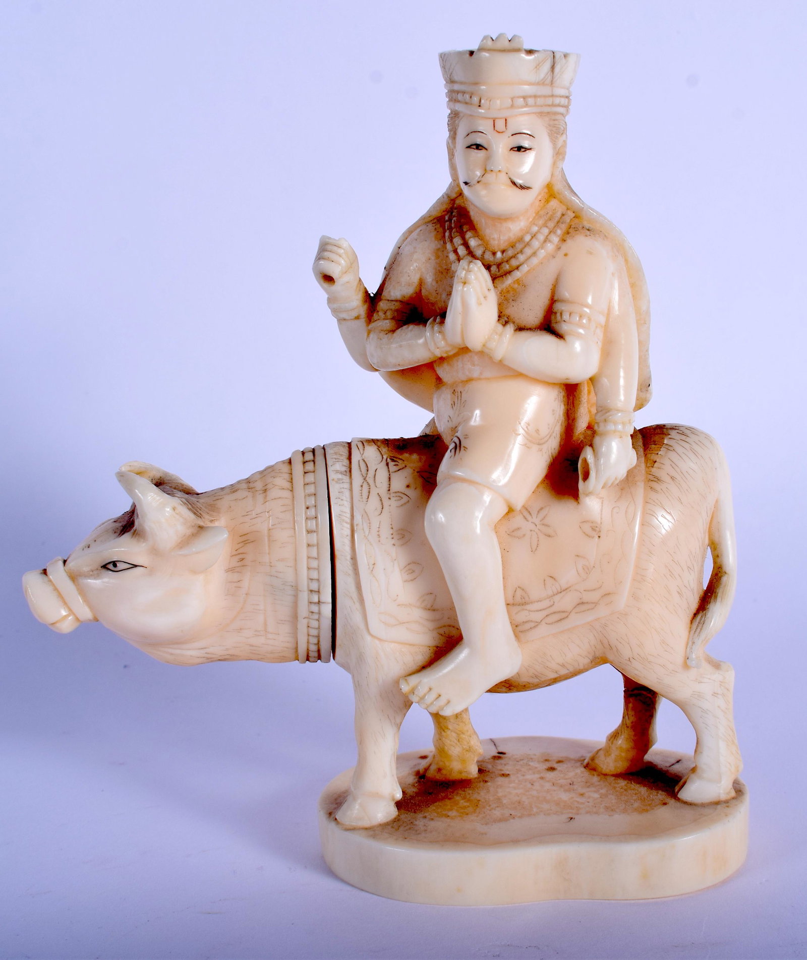 A 19TH CENTURY JAPANESE MEIJI PERIOD CARVED BONE: A 19TH CENTURY JAPANESE MEIJI PERIOD CARVED BONE OKIMONO modelled as a male upon an ox. 12 cm high.
